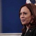 Vice President Harris Under Fire for $157 Million Aid to Lebanon Amid North Carolina Hurricane Recovery A woman speaking with an American flag in background.