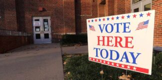 "Vote Here Today" sign outside a building entrance.