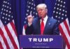 Man speaking at podium with American flags behind
