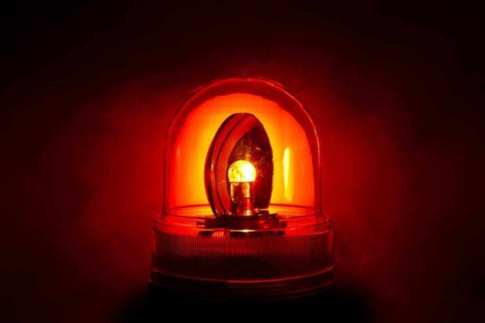 71029123 featured image Red emergency light glowing in darkness.