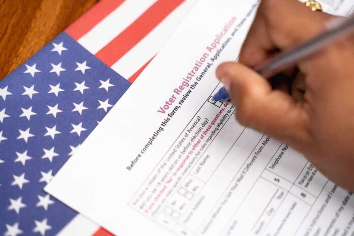 1762483943 featured image Hand filling out voter registration form next to flag.