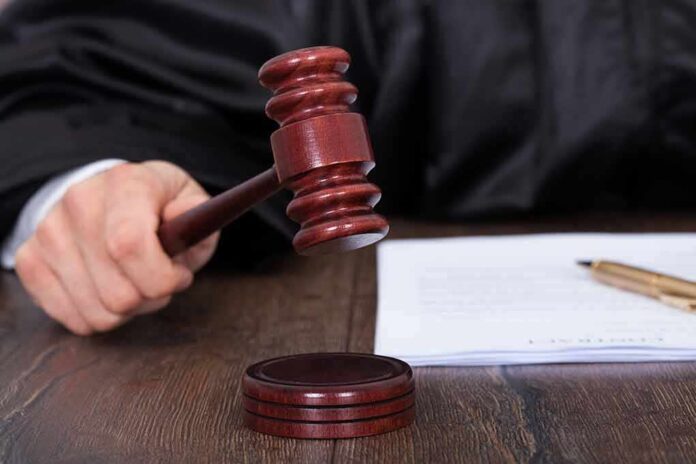 186812807 featured image Judge's hand holding gavel over documents.