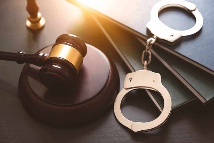 2142035749 featured image Gavel, books, and handcuffs on a table.