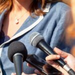 Microphones and smartphone held towards a person speaking