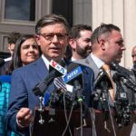 Group of people giving a press conference outside.