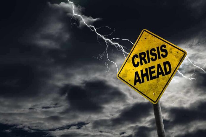 473766712 featured image Yellow "Crisis Ahead" sign with stormy sky.