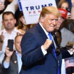 Man in suit standing at a rally event