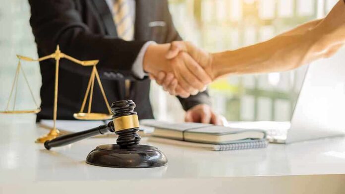 1936290997 featured image Hands shaking over legal documents with gavel and scales