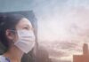 Person wearing a mask in a cityscape background