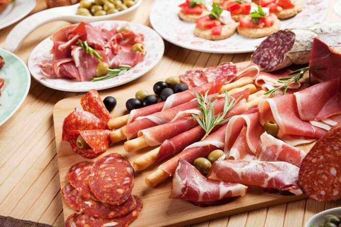 Assorted charcuterie with olives bread and tomatoes on plate