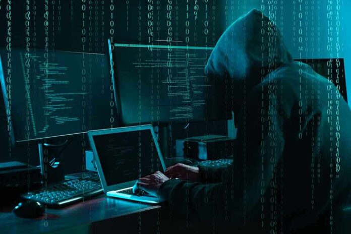 1703023243 featured image Hacker in dark room surrounded by computer screens