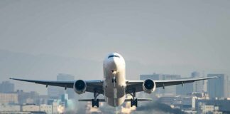 Airplane taking off from runway in urban area