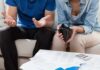 Couple looks worried with empty wallet and bills