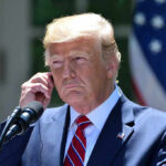 Man in a suit adjusting an earpiece