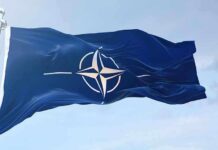 NATO flag waving against blue sky