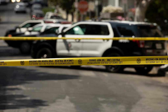 1980603047 Police tape blocking street with patrol cars