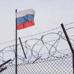 Flag above barbed wire fence