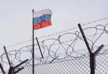 Flag above barbed wire fence