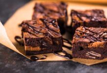 Chocolate brownies with drizzled chocolate on parchment paper