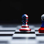 Two chess pawns painted as American and Russian flags