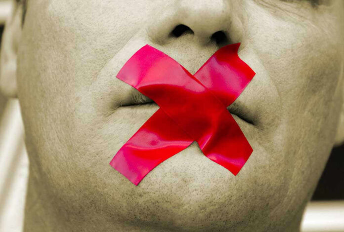 Man with red tape over mouth