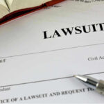Lawsuit paperwork with pen and open book