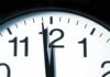 Close up of a clock showing the time just before noon