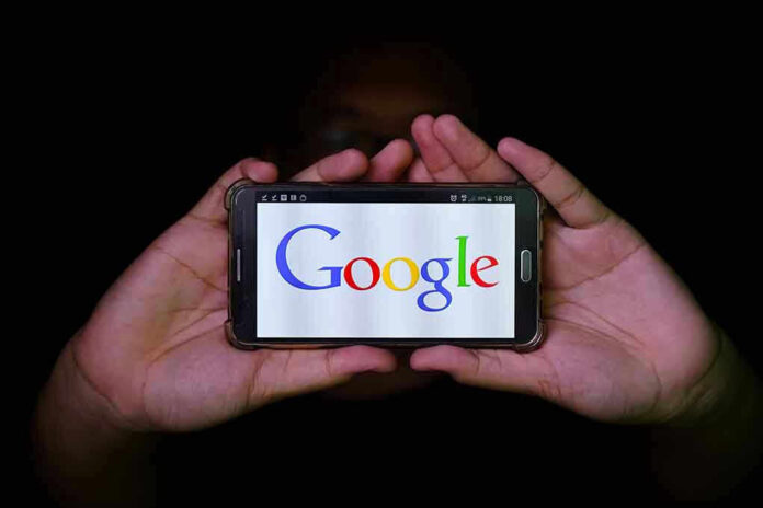 Hands holding smartphone displaying Google logo.