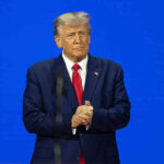Trump’s Power Play Stuns D.C. – What Happens Next? Man in a suit with a blue background.