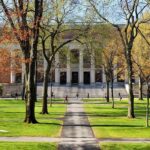 HORRIFYING Animal Torture Exposed At Major University Students walking on a university campus with autumn trees and a historic building in the background
