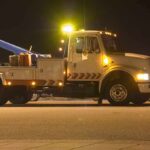 Hidden Evidence Piling Up—97 Cars Discovered! Tow truck with flashing lights parked at night