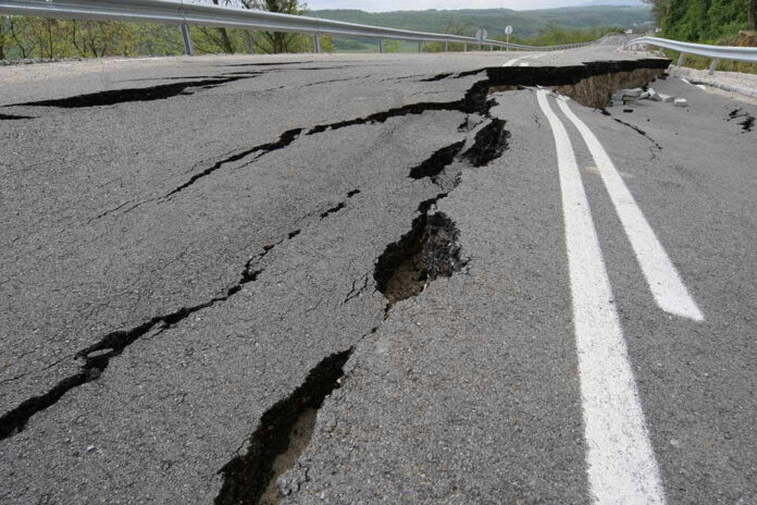 Road damaged by significant cracks and fissures.