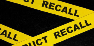 Yellow tape with product recall text on black background.