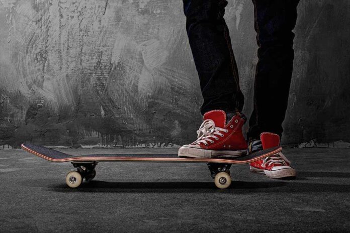 shutterstock_112638143.jpg Person standing on a skateboard wearing red sneakers