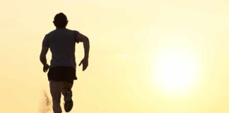 Silhouette of a man running on the beach during sunset