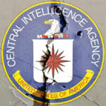 Cracked CIA logo on weathered wall.