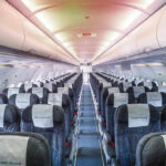 Empty airplane cabin with rows of seats.