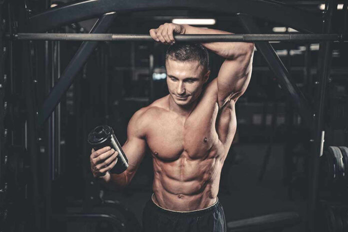 Muscular man in gym holding a shaker bottle