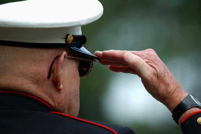 A veteran in military uniform saluting with a hand raised