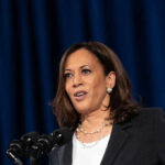 Woman speaking at a podium with microphones.