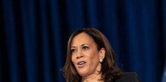Woman speaking at a podium with microphones.