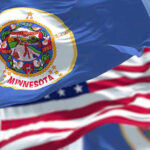 Holocaust Comparison Ignites Minnesota Firestorm Minnesota state flag with American flag in background.