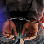 ICE’s Bold Move—Child Predators Rounded Up Person in handcuffs with colorful lights in background.