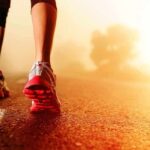 Person jogging on a road during sunrise