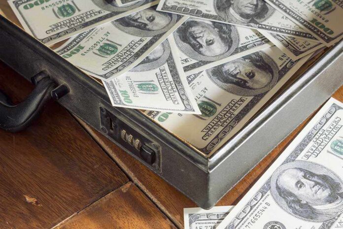 A briefcase filled with hundred dollar bills on a wooden surface