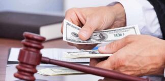 A person counting cash in a courtroom setting with a gavel in the foreground