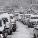 Russian Strikes Leave Kyiv Freezing in Darkness Traffic jam with cars covered in heavy snow during a snowstorm