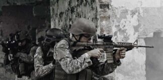 Soldiers in tactical gear advancing through a damaged building