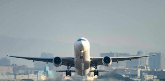 Airplane taking off from runway in urban area