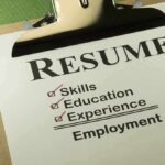 A resume checklist on a clipboard highlighting skills, education, experience, and employment